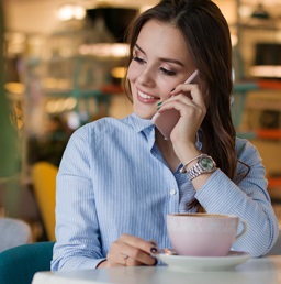 A photo of a woman talking on the phone at a coffee shop
