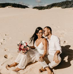 couple sitting on shore during daytime